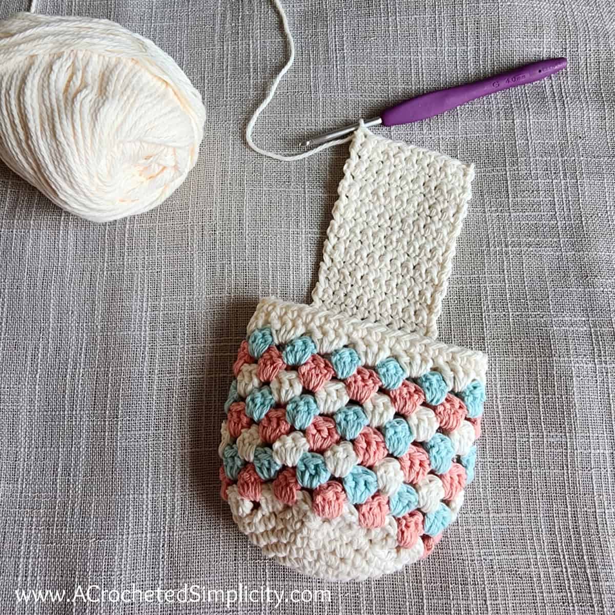 Cream, aqua, and tangerine cotton yarn drink caddy worked in the granny stitch crochet.