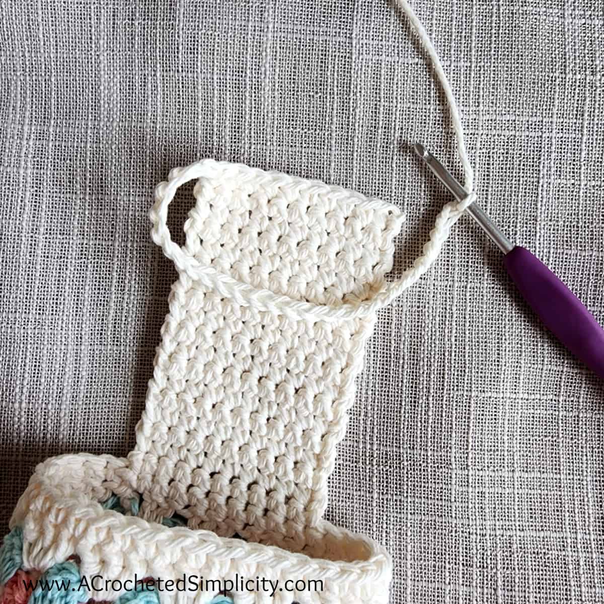 Crochet chain begins the cell phone pouch on a crochet chair caddy.