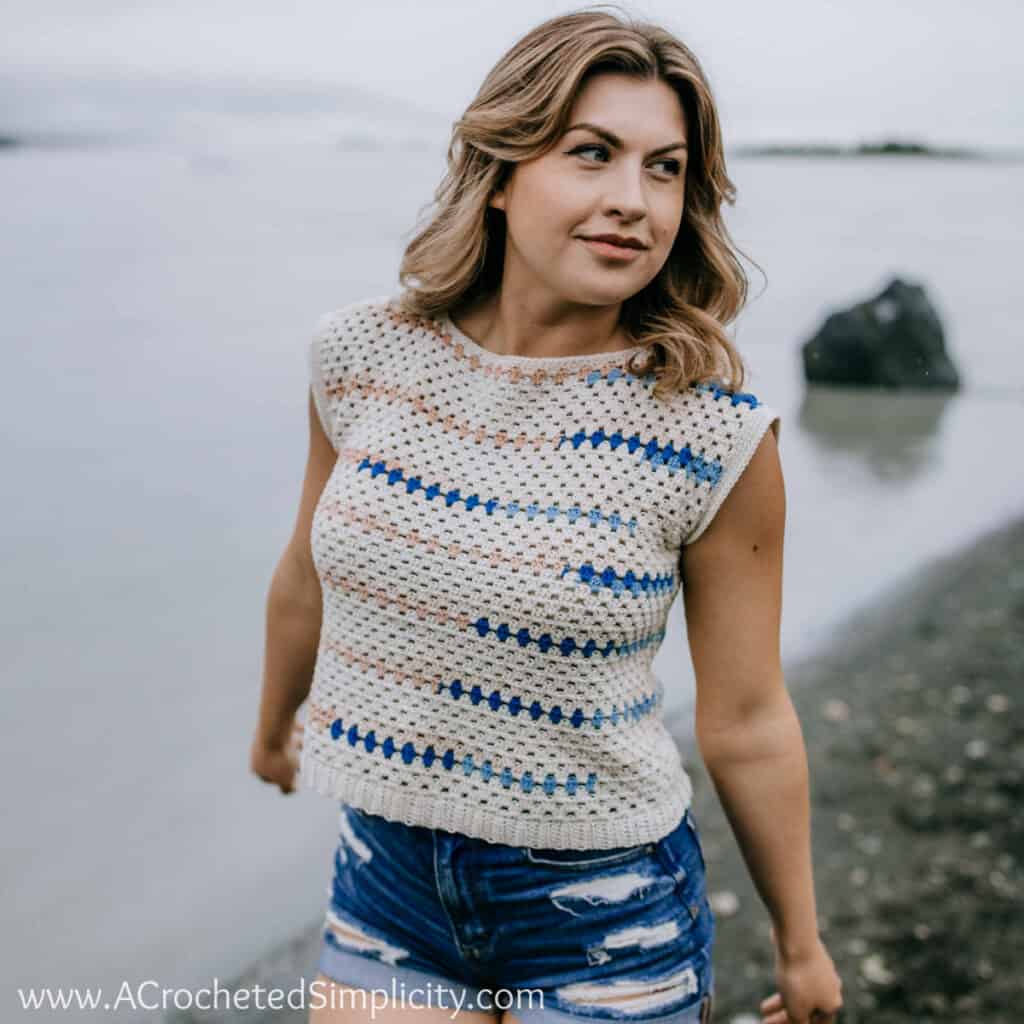 Woman on a beach modeling a boho inspired crochet top pattern.