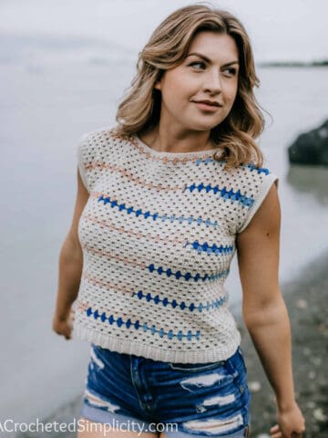 Woman on a beach modeling a boho inspired crochet top pattern.
