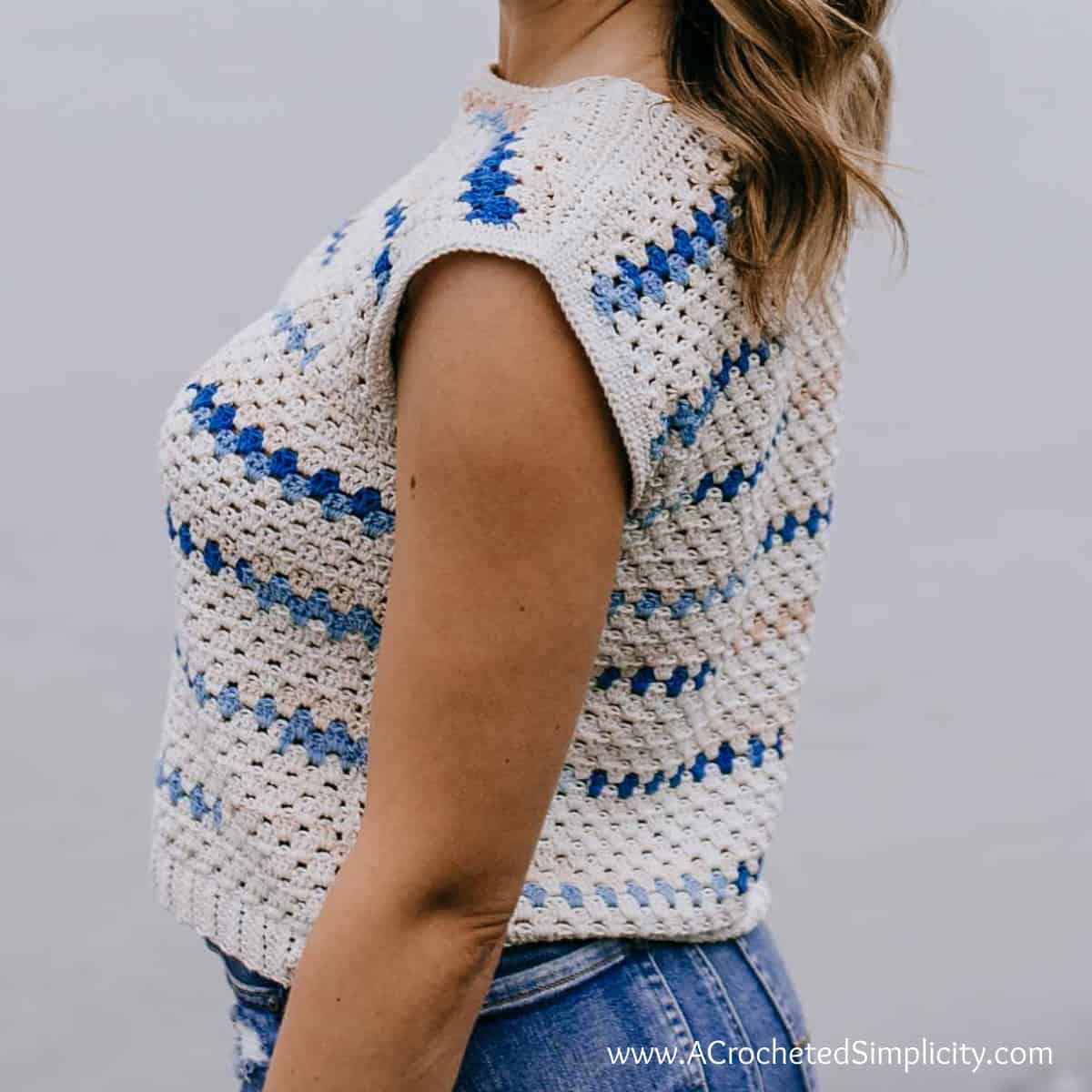 Close up of a woman on a beach modeling a boho inspired crochet blouse.