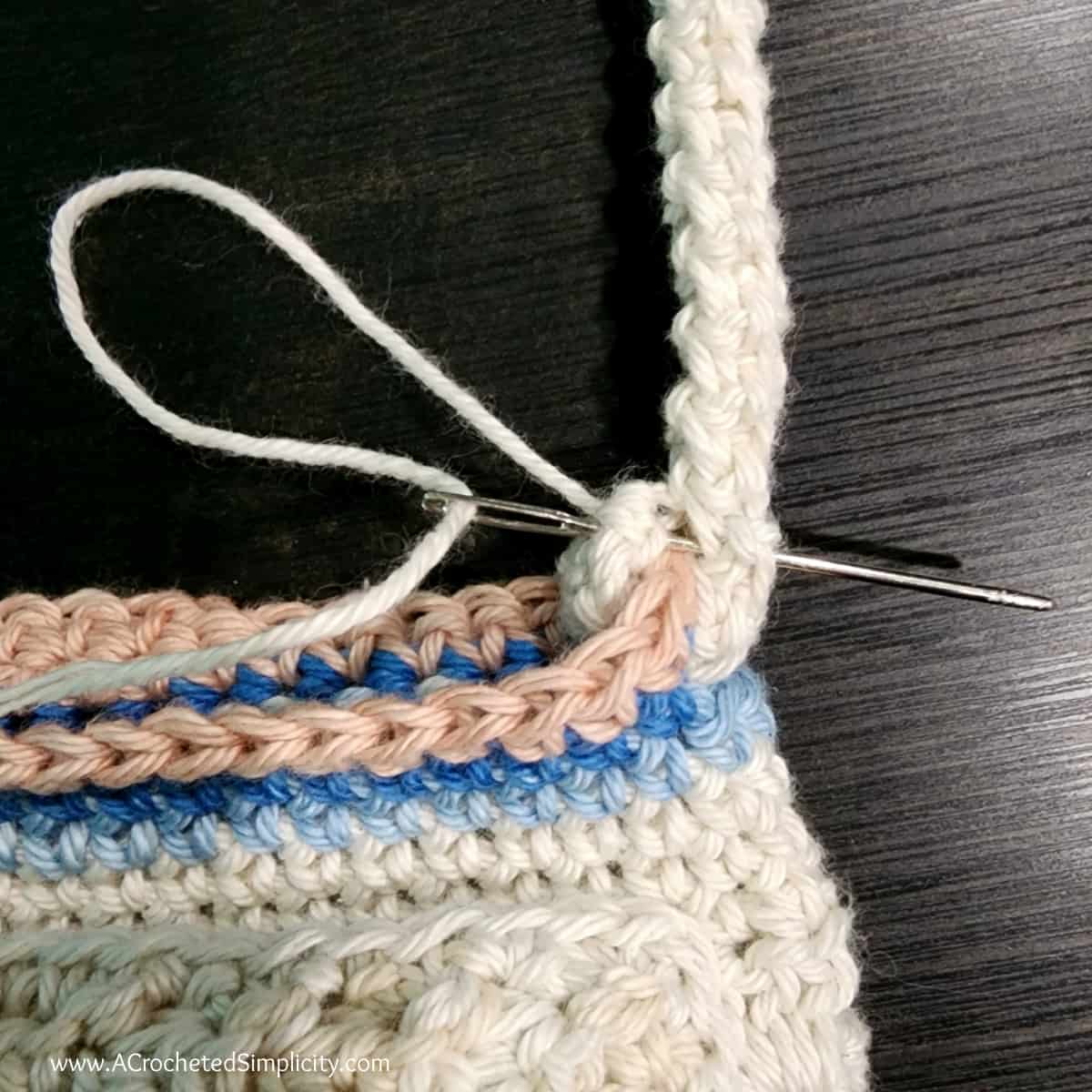 Photo tutorial showing how to secure the stationary crochet rope strap to the water bottle holder.