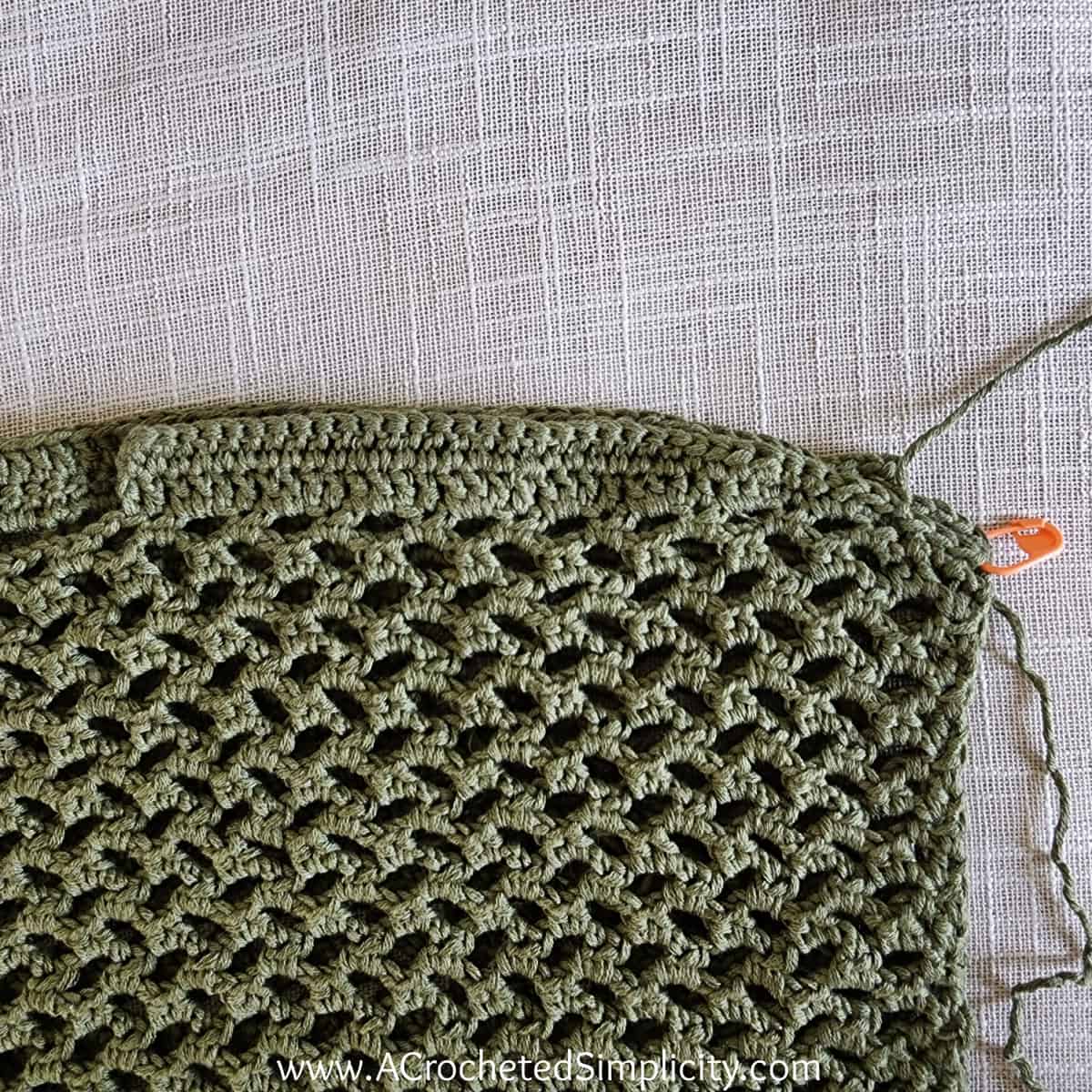 Close up showing how to seam the shoulders on a mesh top crochet.