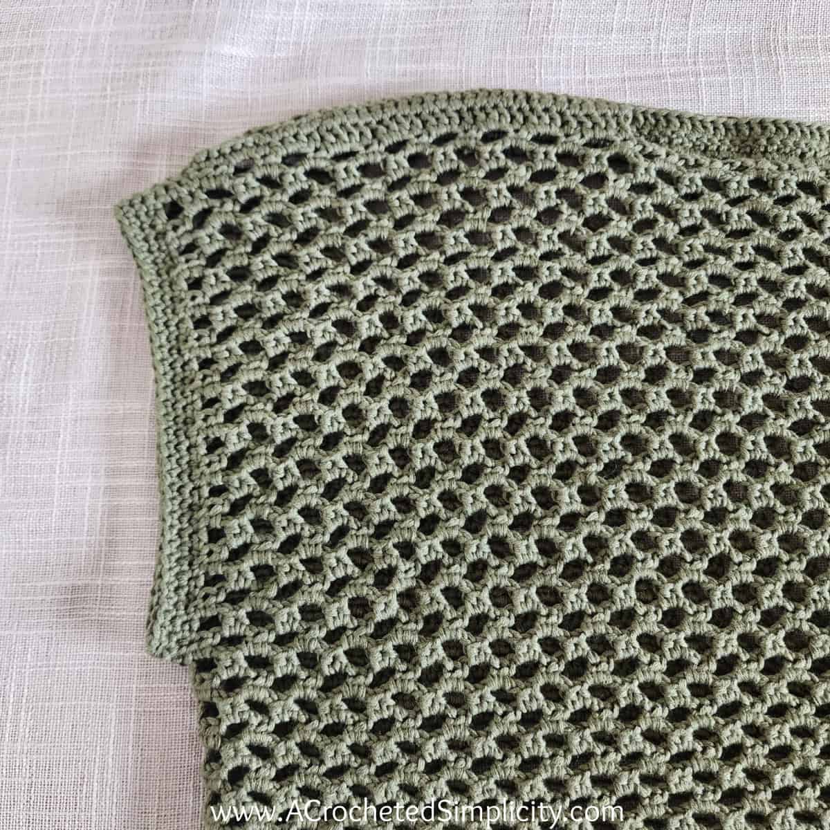 Close up of mesh crochet top showing sleeve edging.