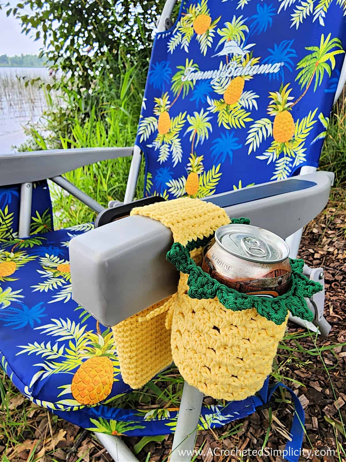 Crochet pineapple chair caddy hanging on beach chair with phone pocket.