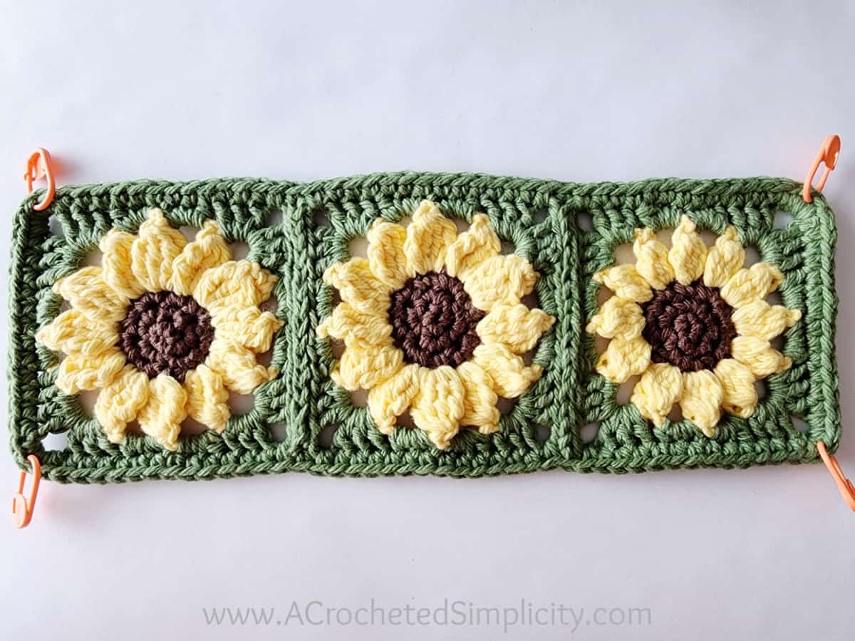 Three sunflower motifs joined to form a rectangle and all edged with a single crochet.