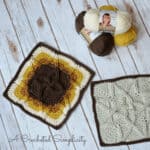 Two crochet cabled 12 inch blanket squares laying on white washed wood.