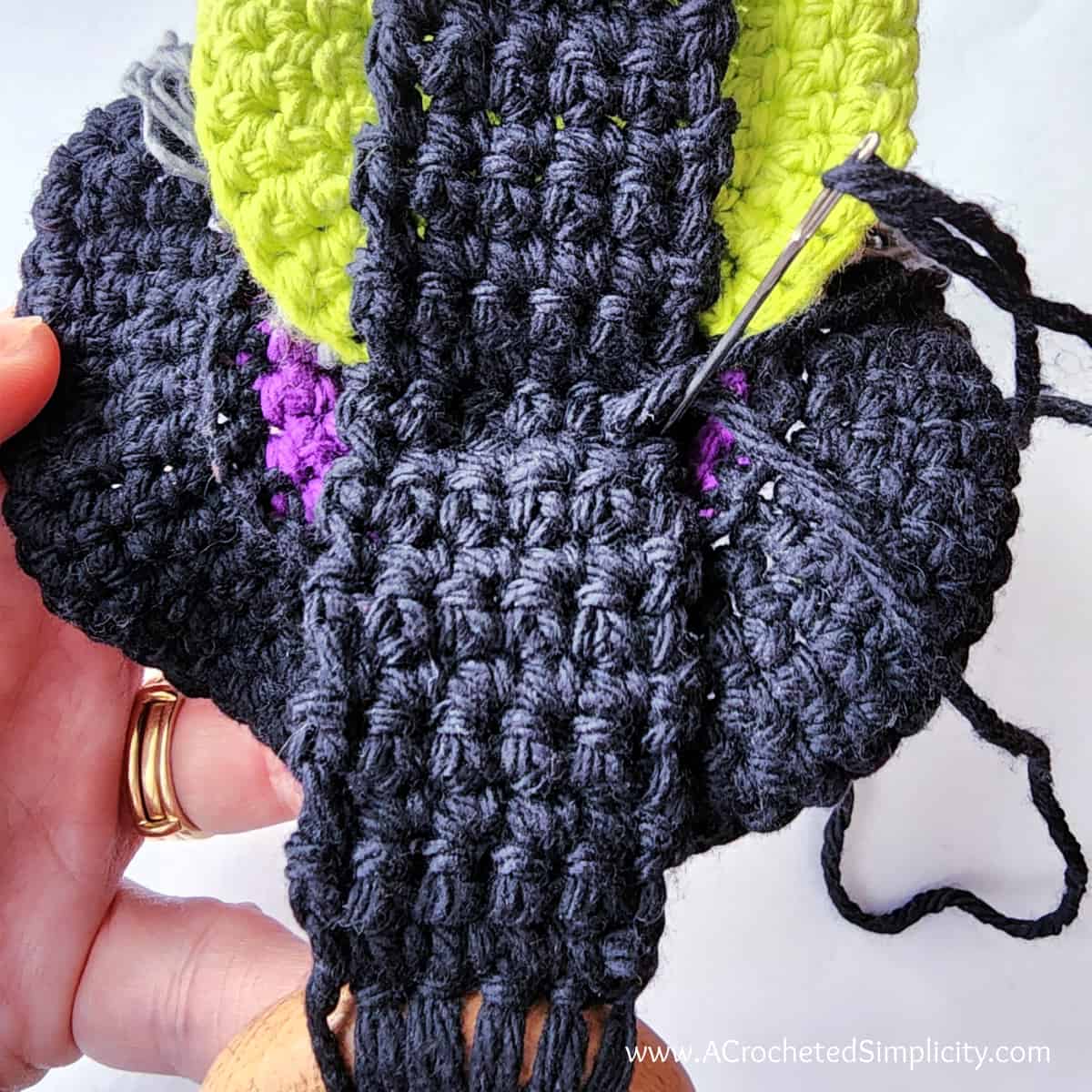 Attach the crochet hanging loop to the back of the witch's head.