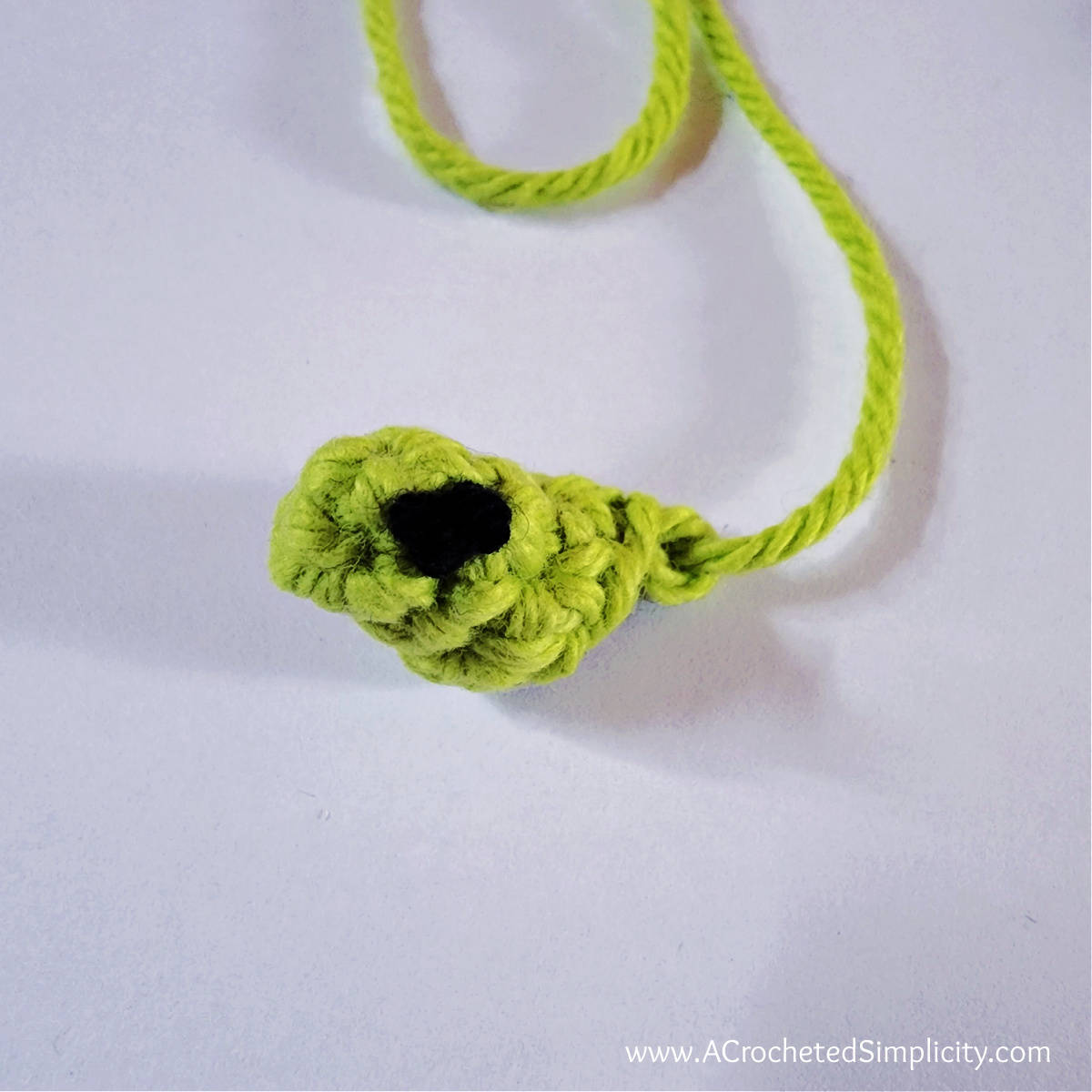 Green witch's crochet nose with black wart.