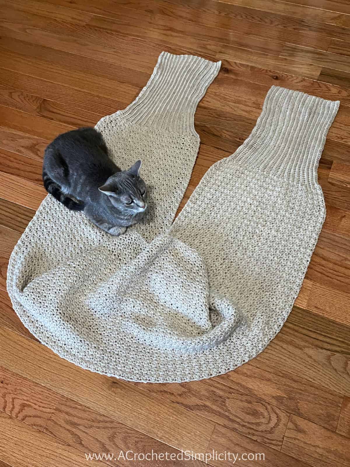 Grey kitty cat laying on a crochet sweater sc arf