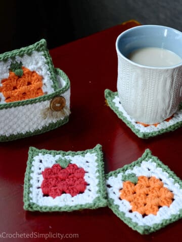 Fall crochet coaster set with holder sitting on red table