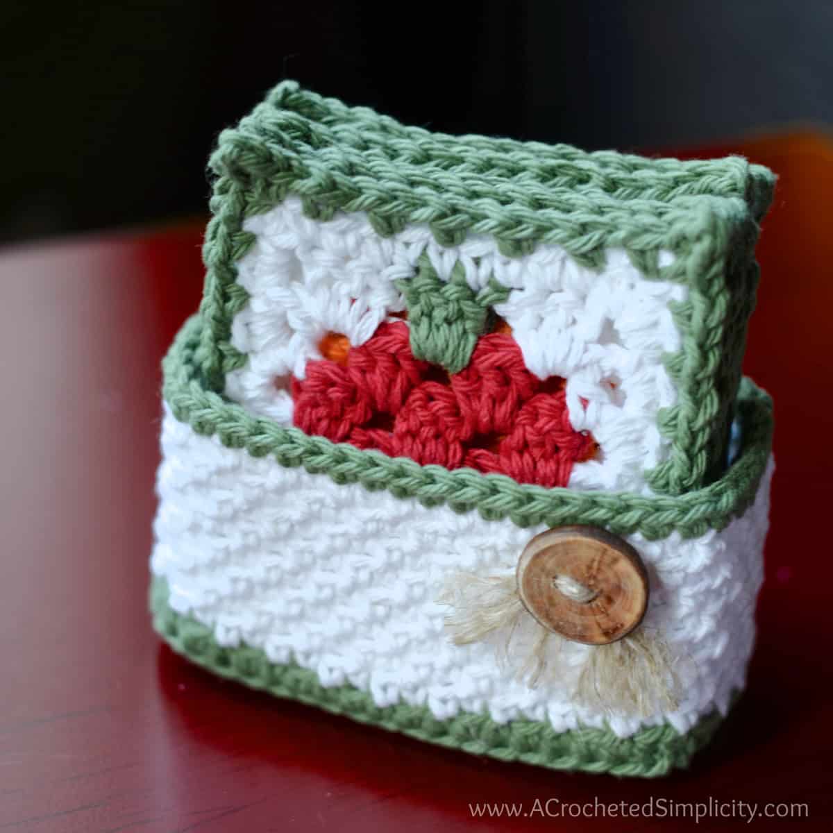 Apple crochet coaster set with holder sitting on red table