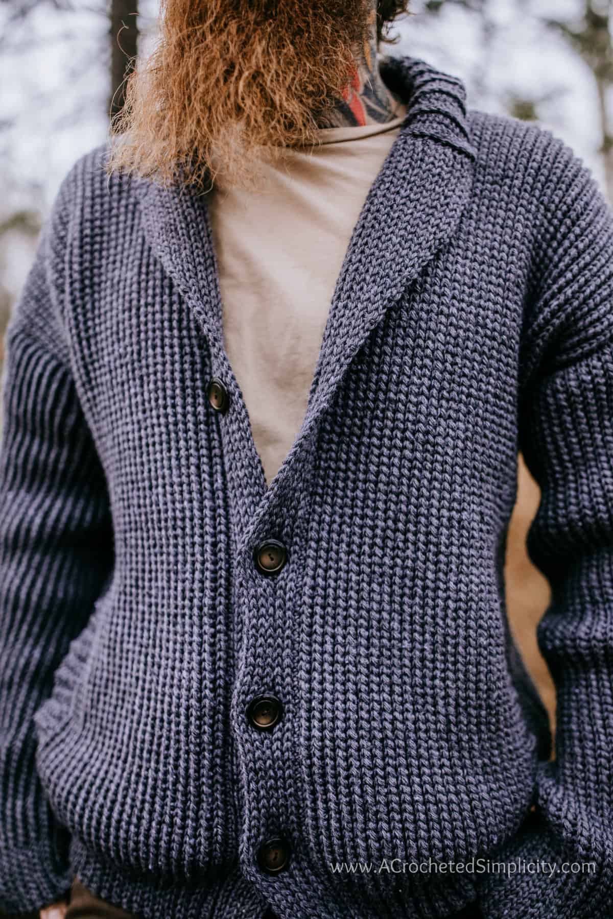 Close up of model wearing men's crochet cardigan with buttons