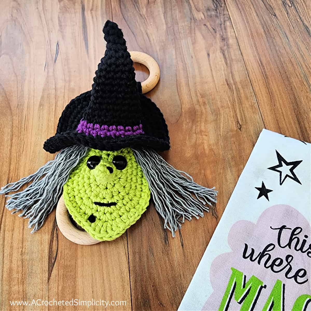 Witch crochet towel ring holder with ring laying on wooden floor