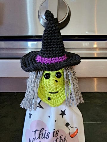 Close up of crochet witch towel ring holder holding halloween hand towel