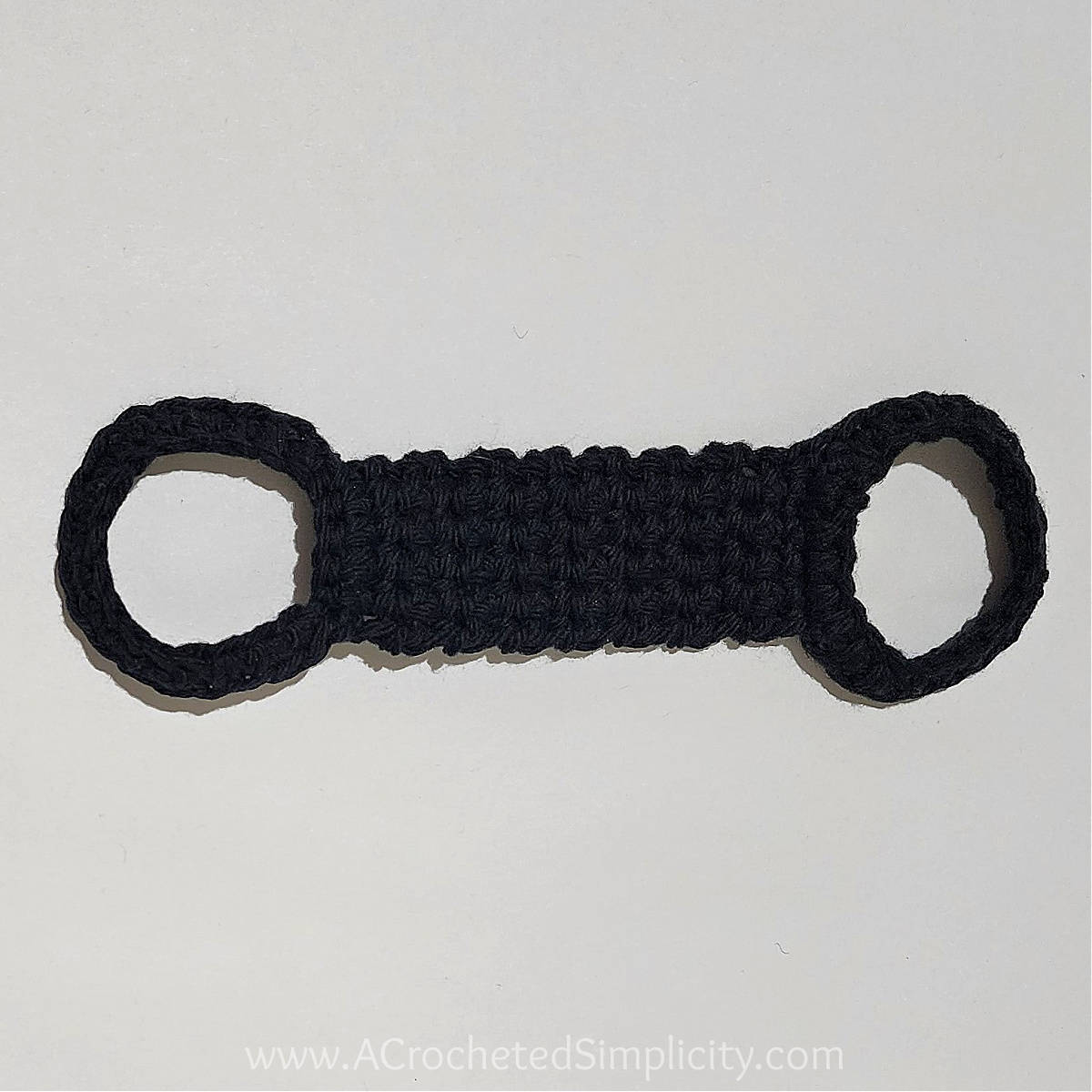 Crochet kitchen towel holder in black yarn.