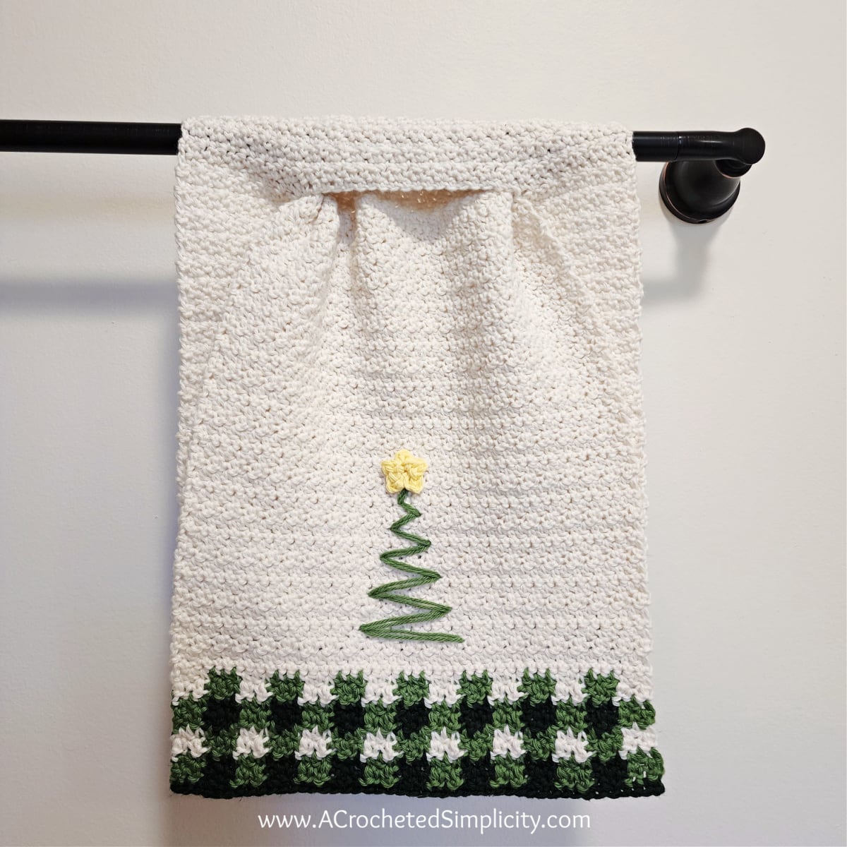 Christmas tree crochet hand towel with buffalo plaid hanging on towel bar