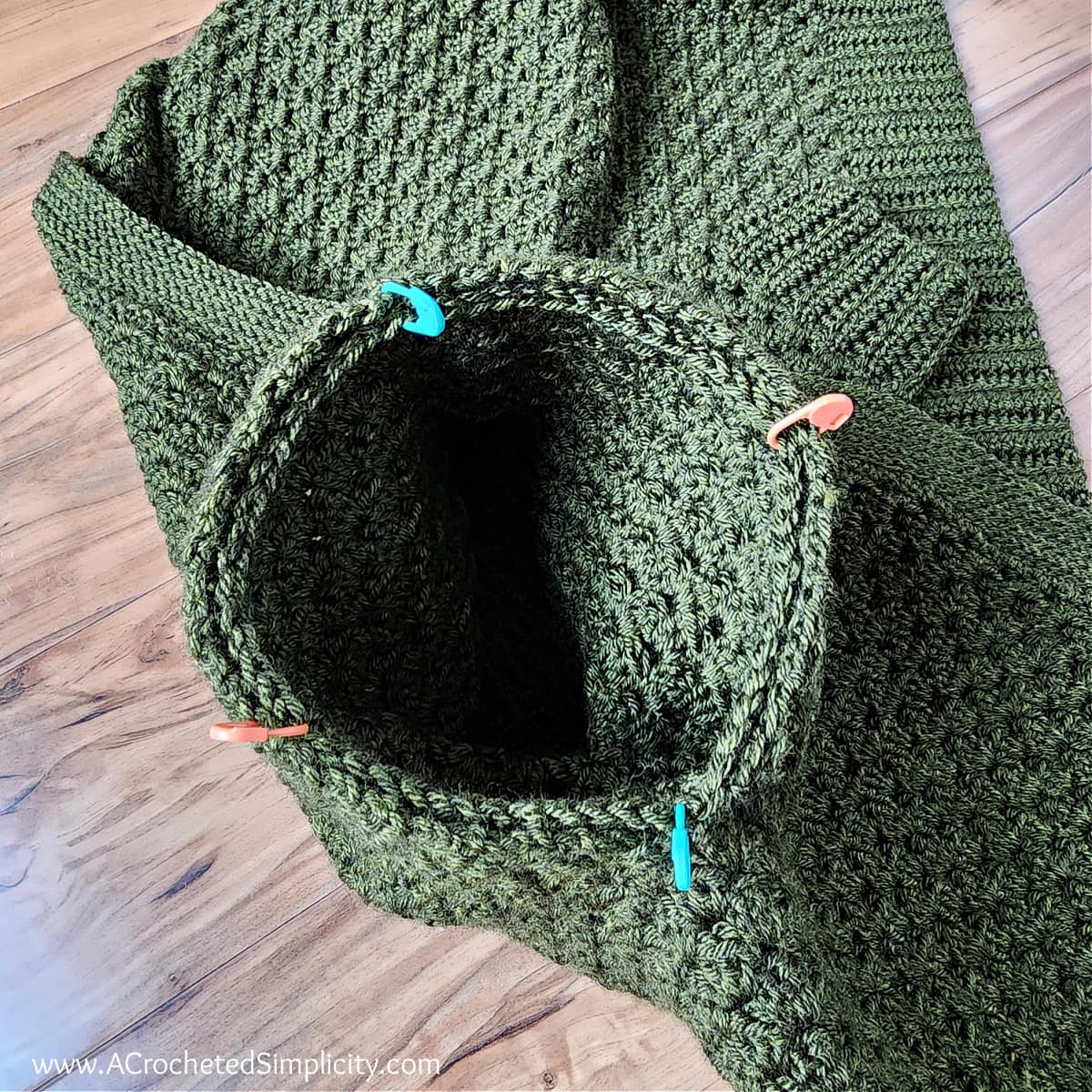 sleeve being whipstitched onto button up crochet cardigan