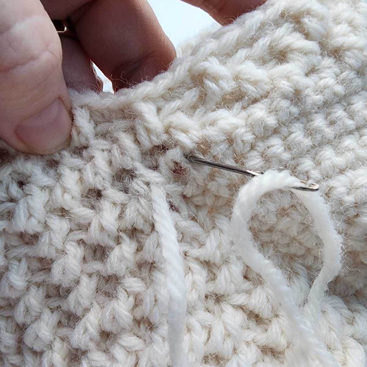 Use a yarn needle to close the gap in the corner of the heel of a stocking.