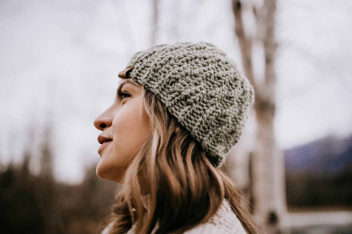 side view of knit look crochet beanie modeled by woman outside