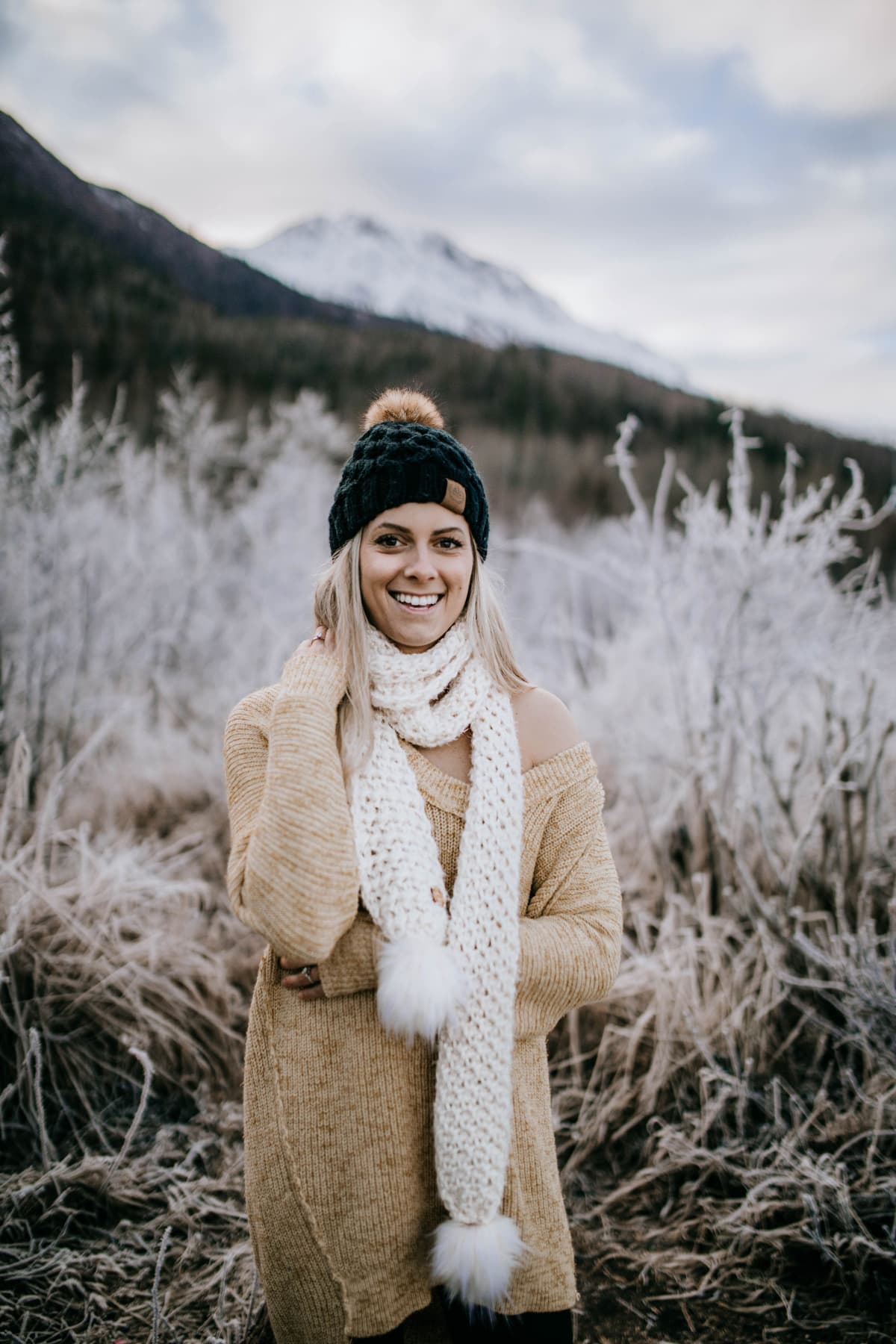 Woman modeling chunky crochet scarf near mountains