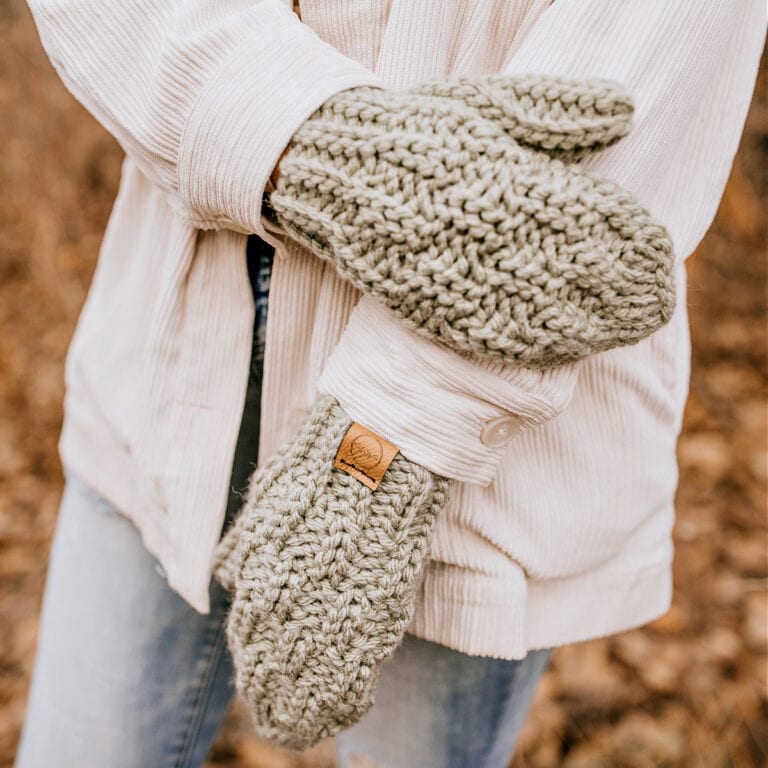 light green knit look crochet mittens with leather tag modeled outdoors