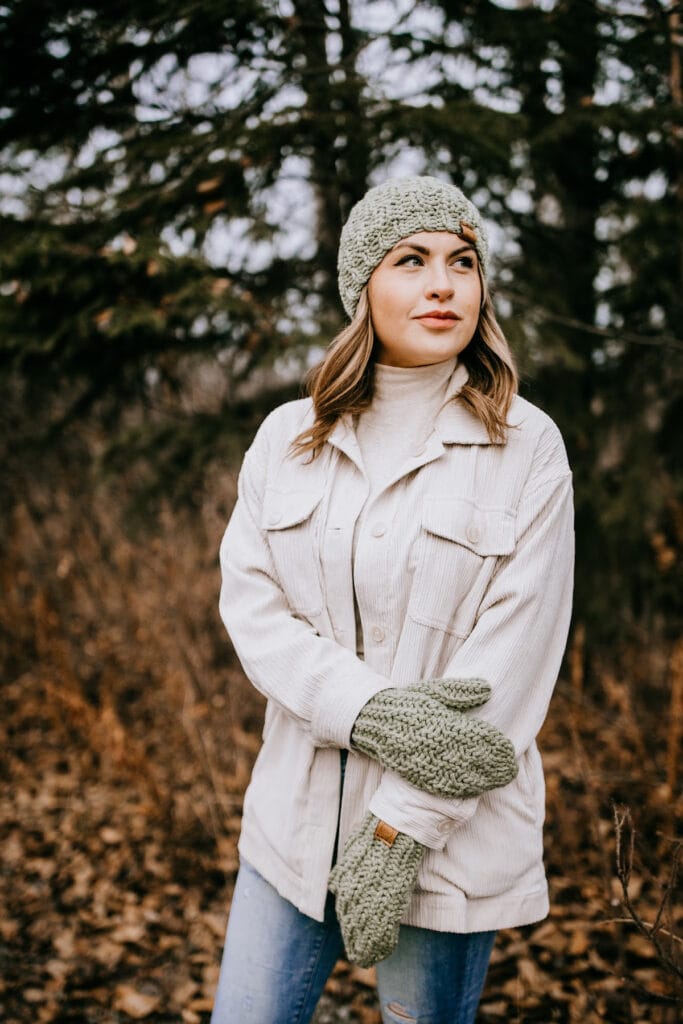 woman modeling light green chunky beanie and mittens outdoors wearing cream jacket