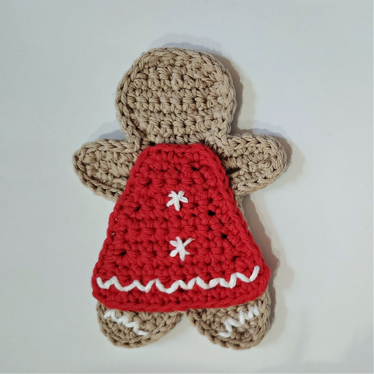 crochet gingerbread girl wearing red dress with ric rac trim