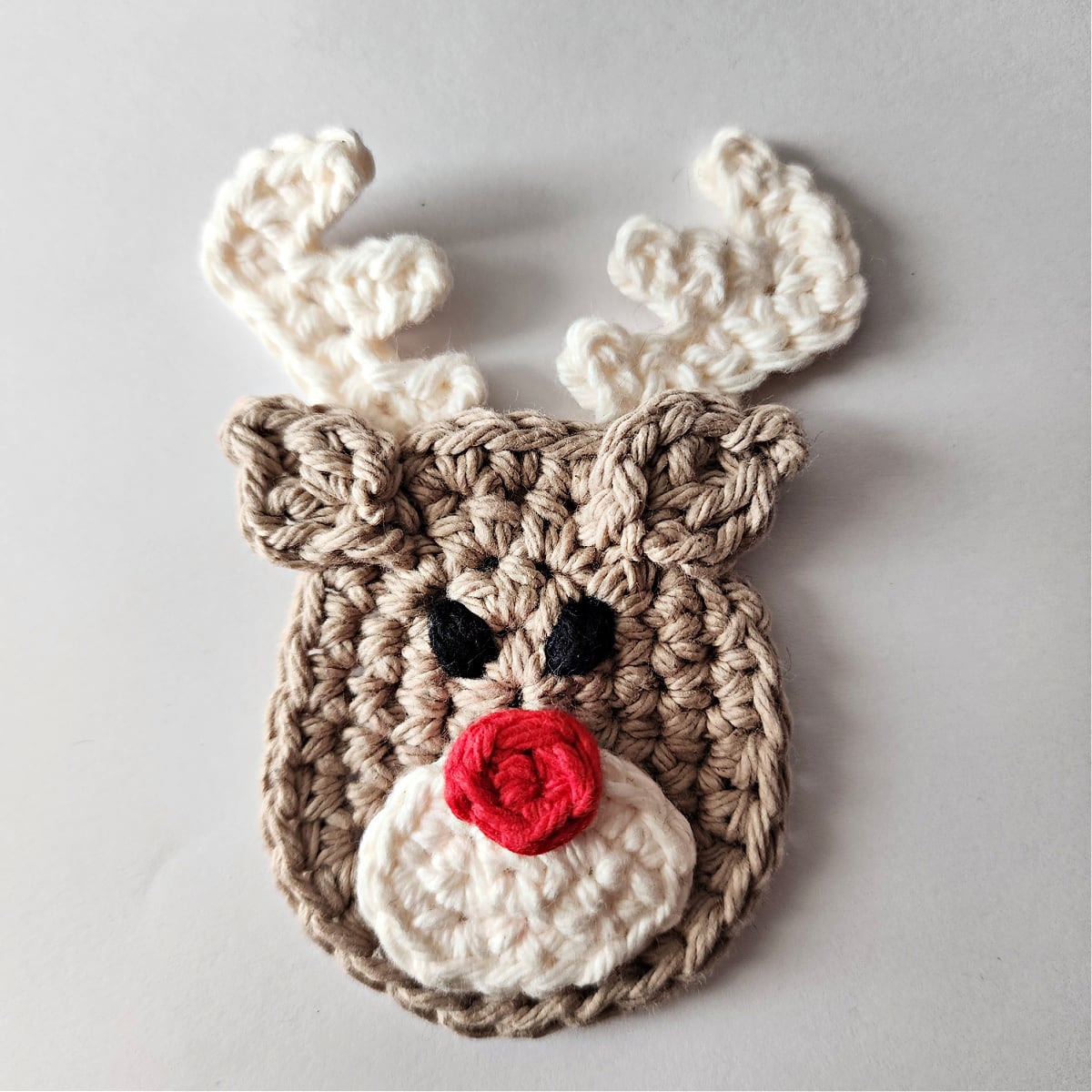 Adding ears to the crochet reindeer ornament.