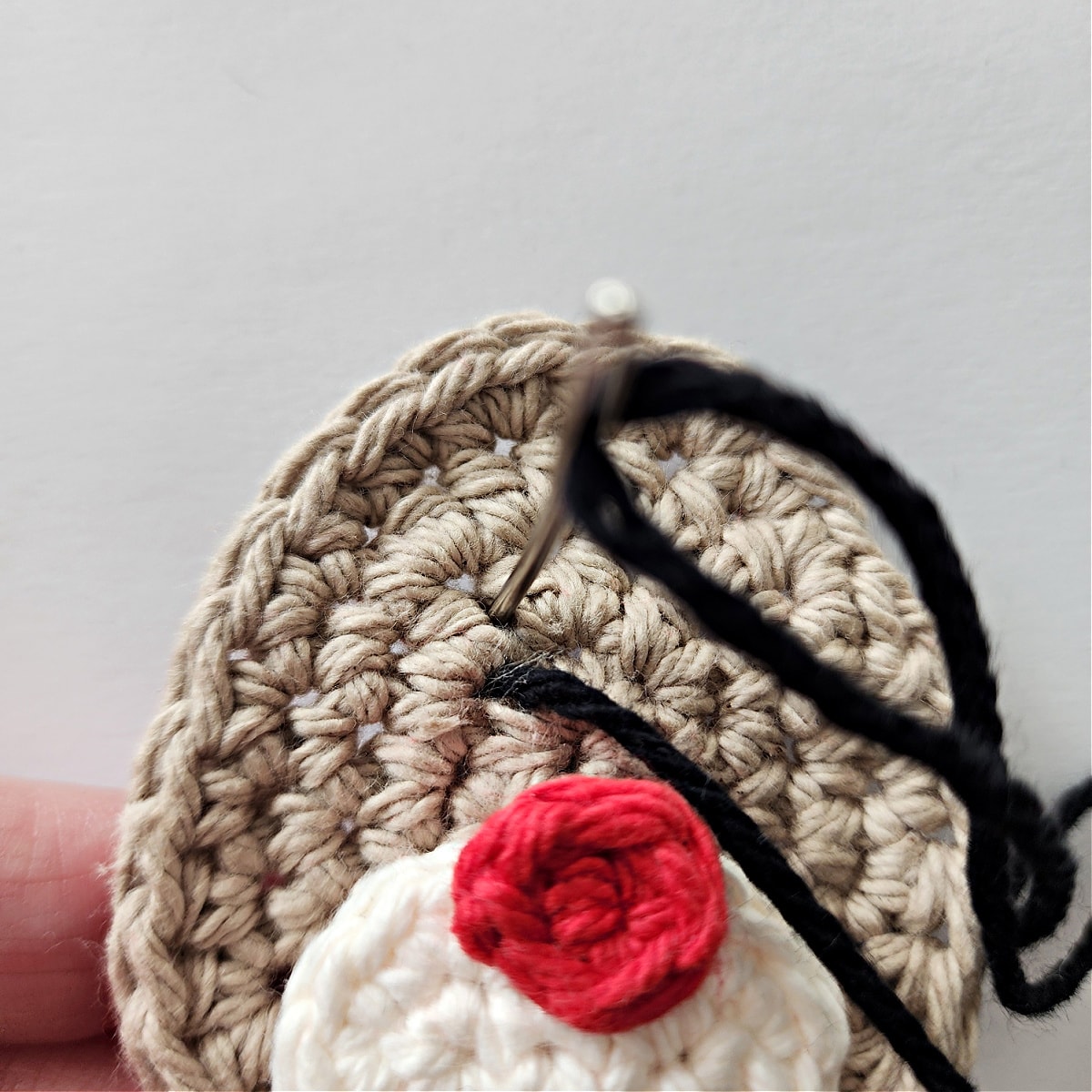 Begin to embroider crochet reindeer eyes.