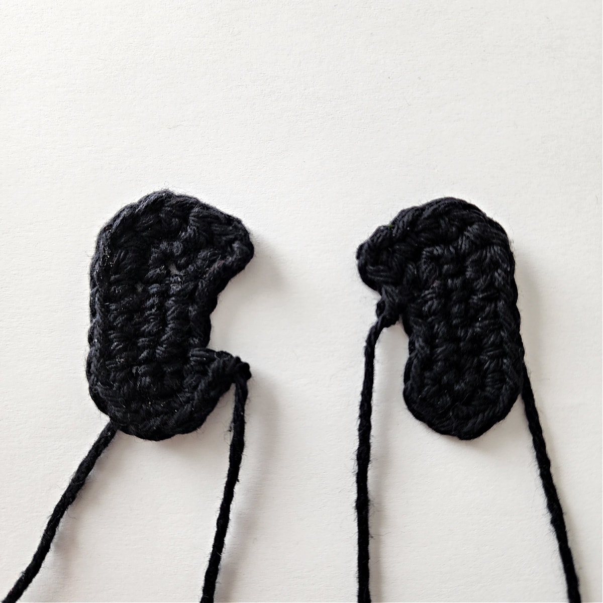 Two black crochet reindeer hooves.