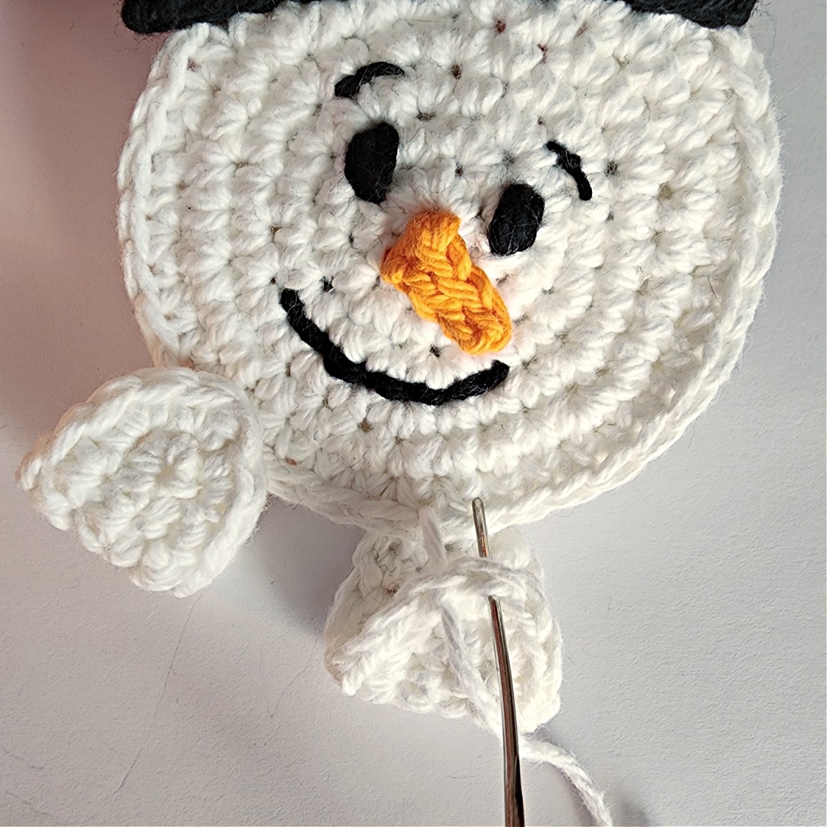 sew crochet hand onto bottom edge of snowman face photo 2