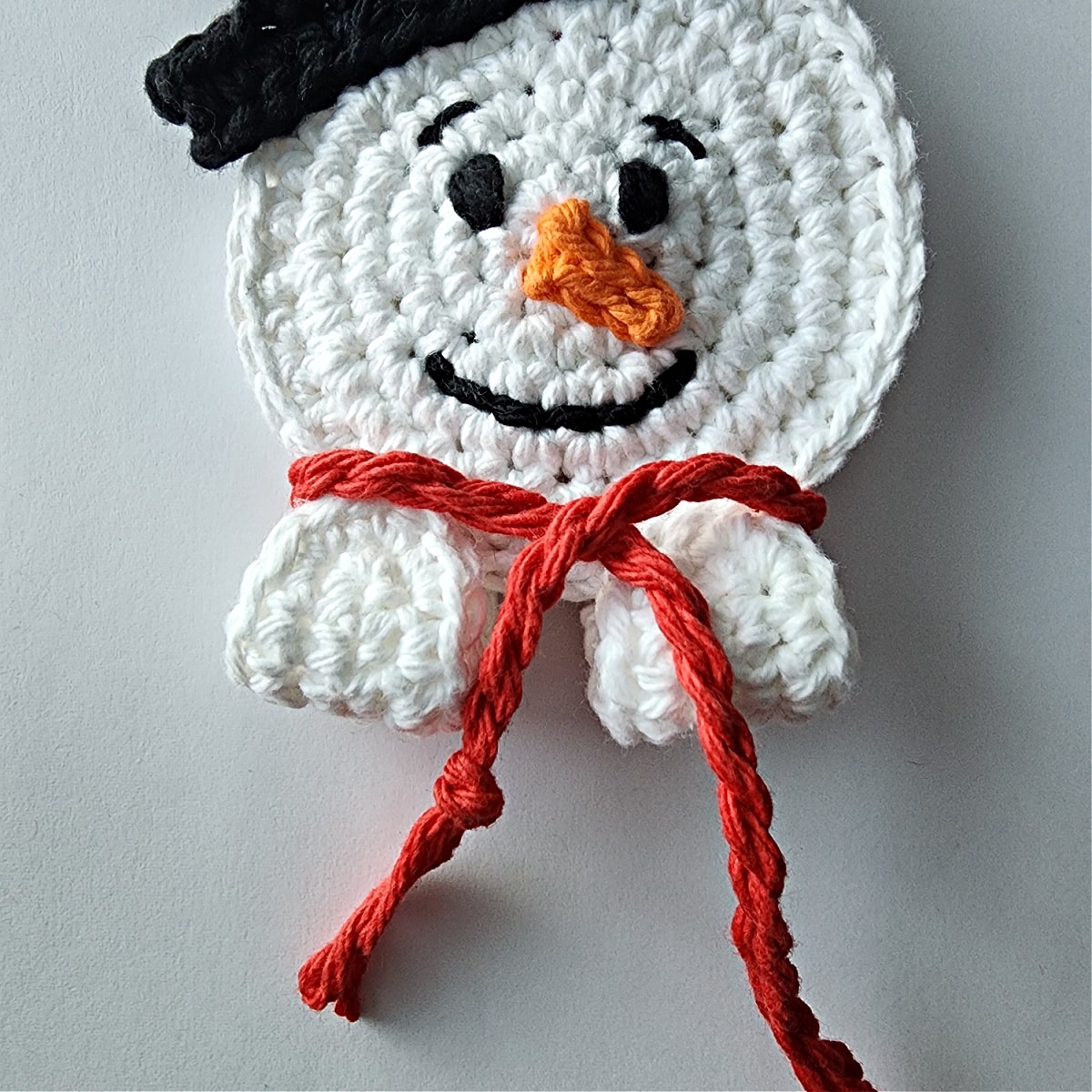 yarn rop scarf wrapped around snowmans head