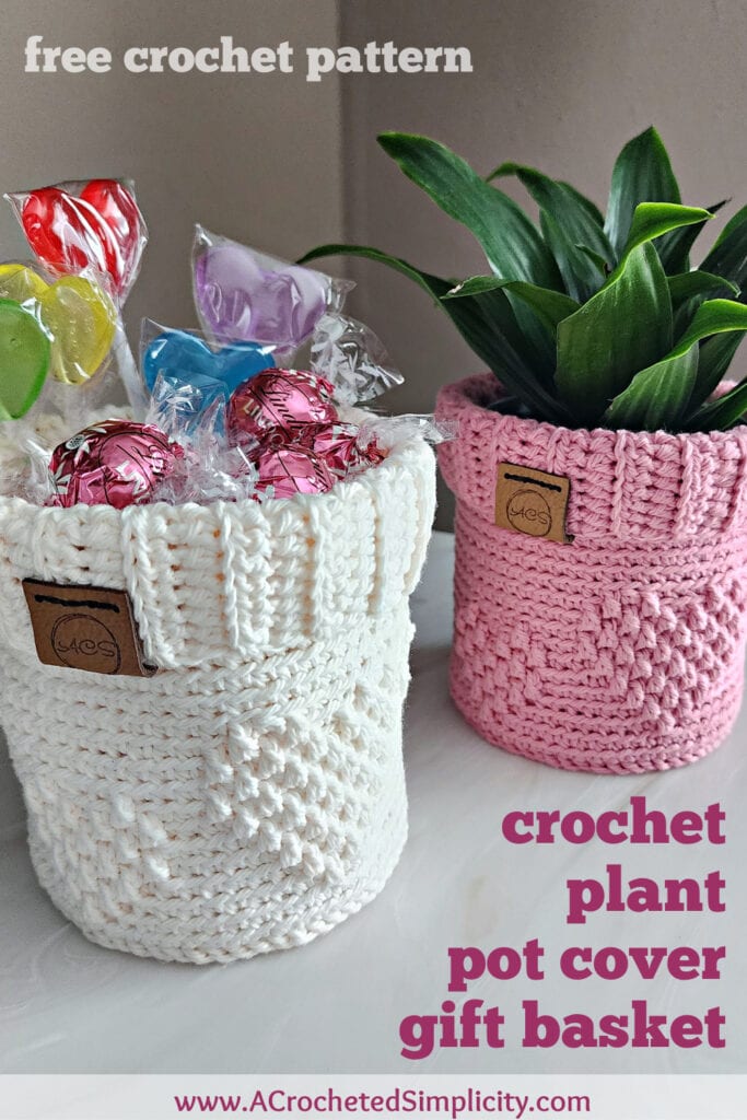Cream crochet gift basket filled with candy and a pink crochet flower pot holder with a small green plant.