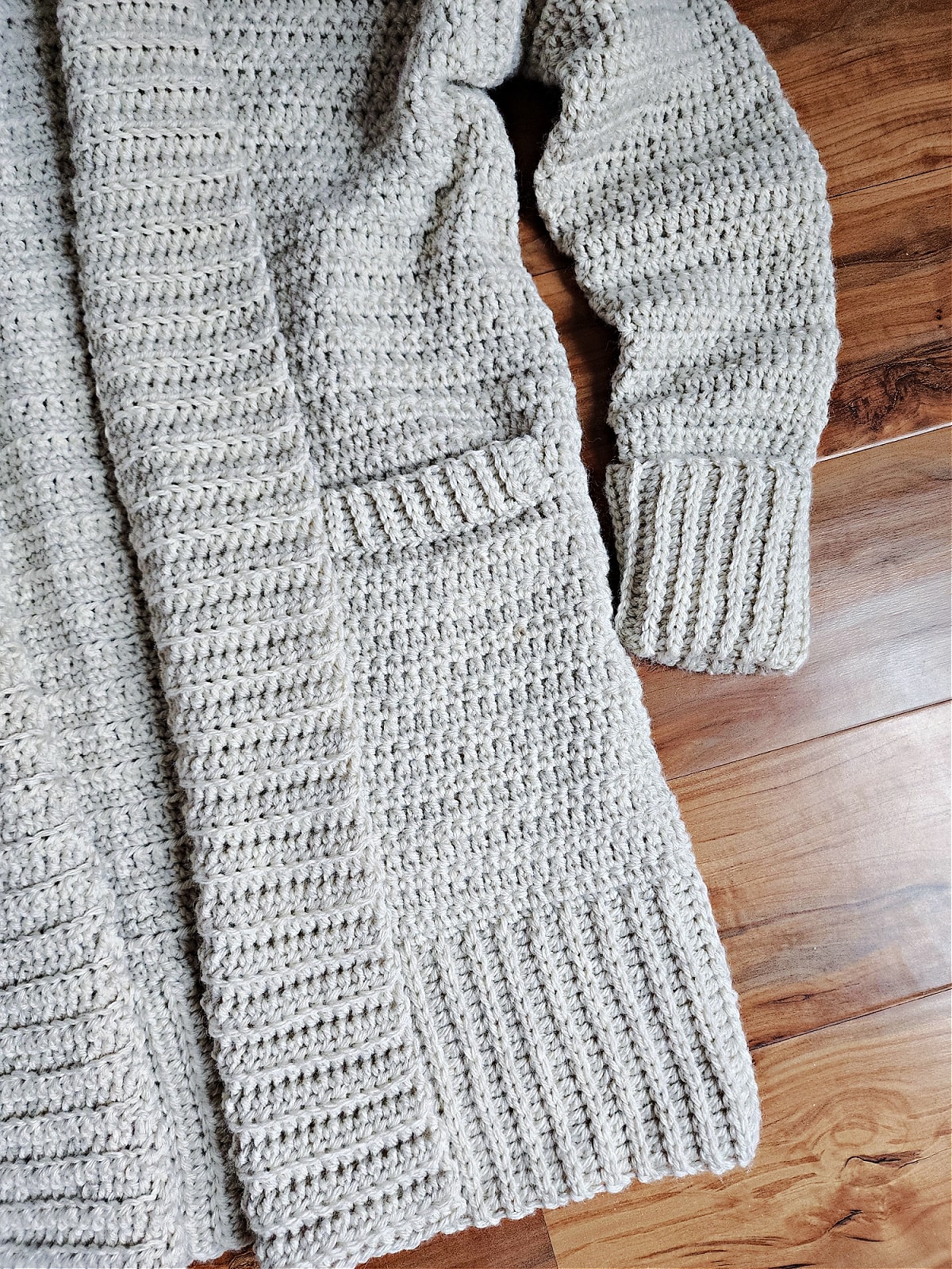 Close up of beige women's cardigan pocket.