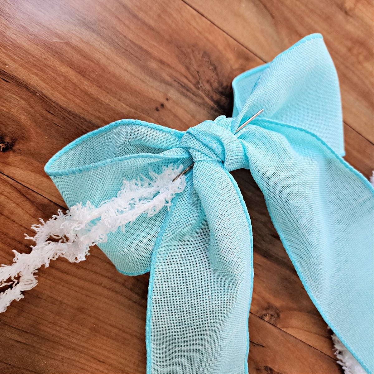 Light blue 2.5" wide dollar tree ribbon bow with yarn to attach to wreath.