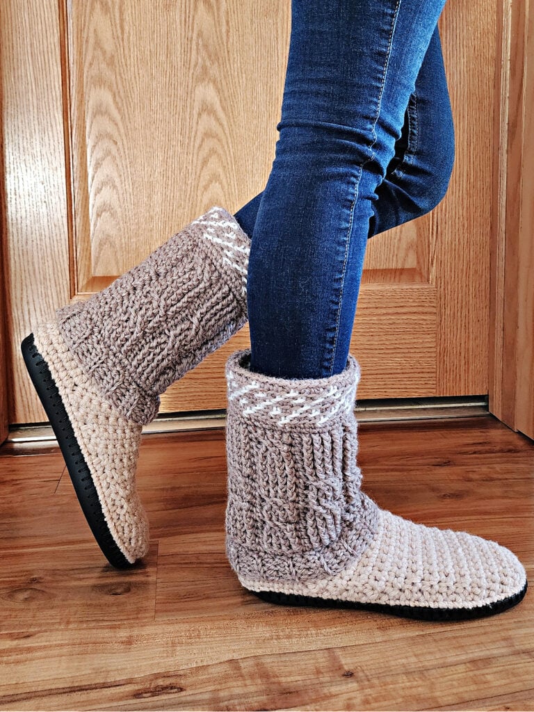 Cable crochet slipper boots with soles and tall crochet cuffs.