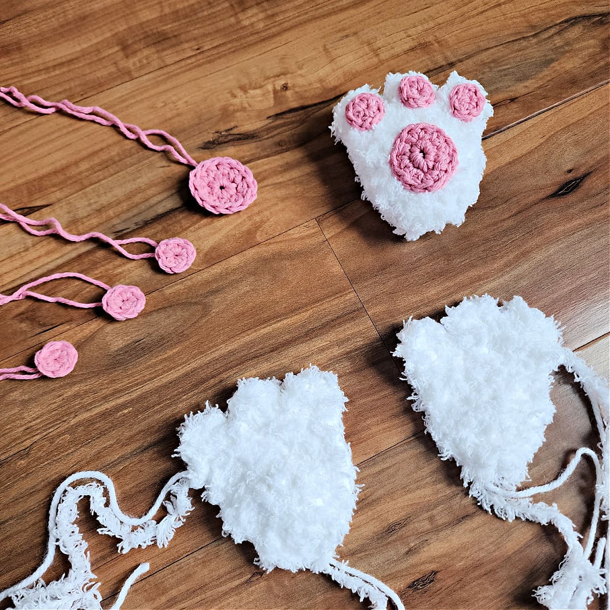 Crochet bunny feet laying on floor waiting to be sewn together.