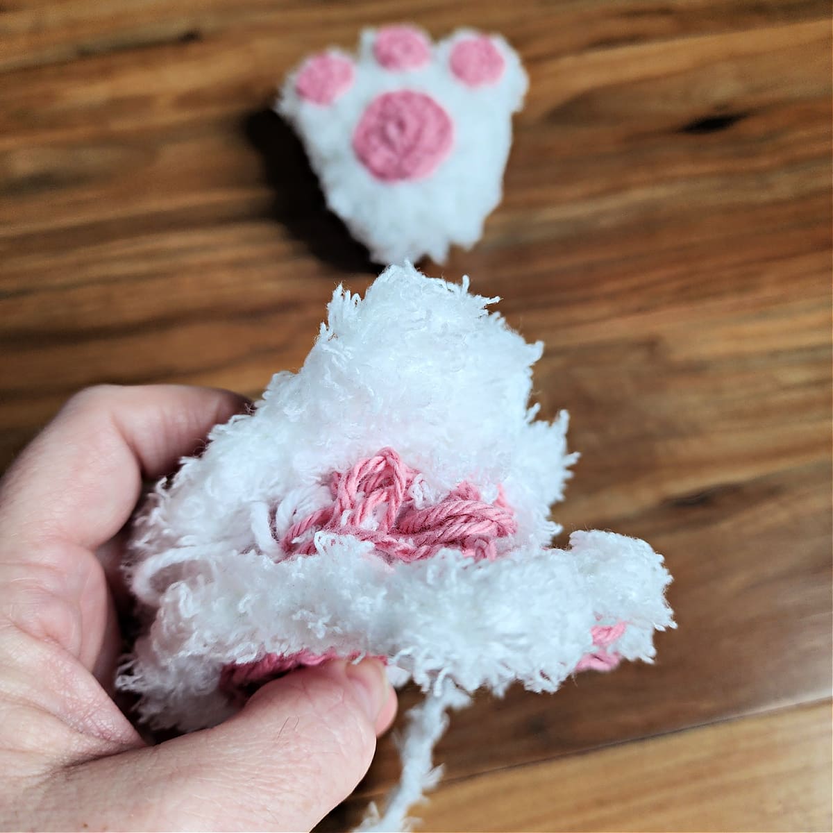 Crocheted bunny feet being seamed.