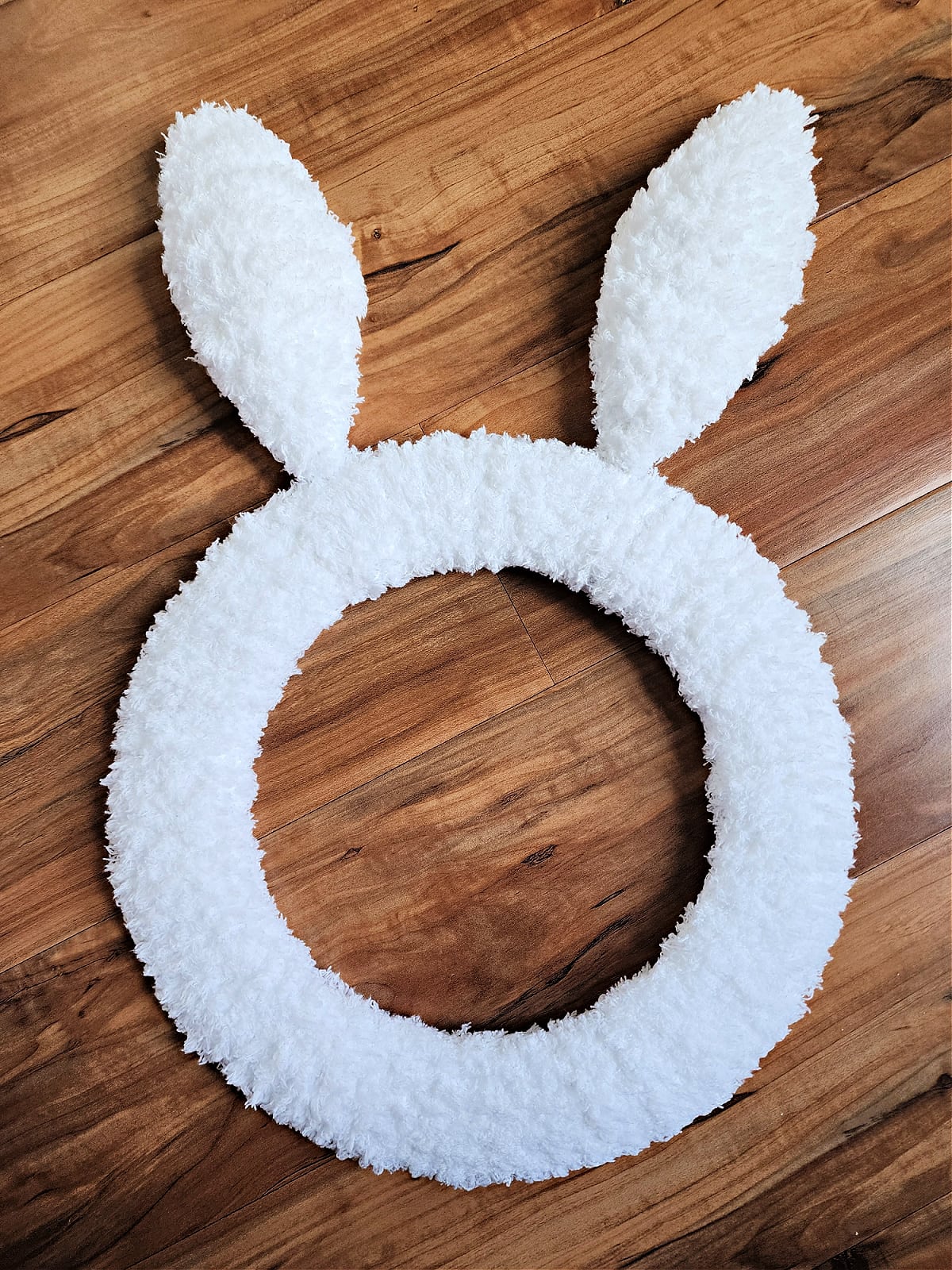 Bunny wreath with coat hanger ears covered in yarn ready to embellish.