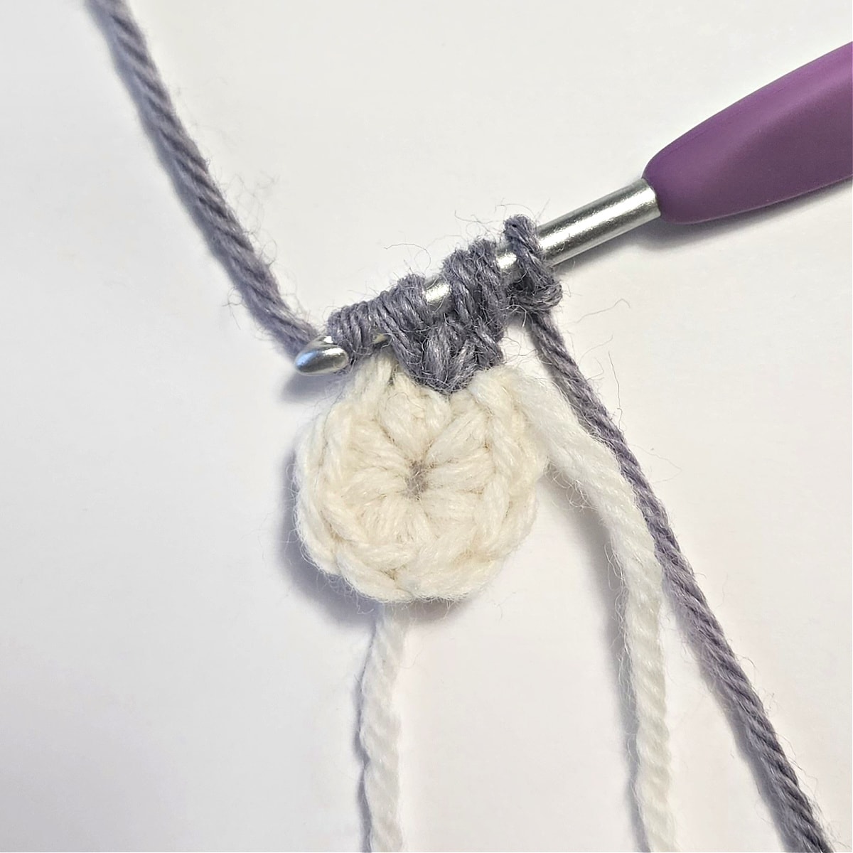 Small crochet swatch with a crochet cluster stitch being worked.