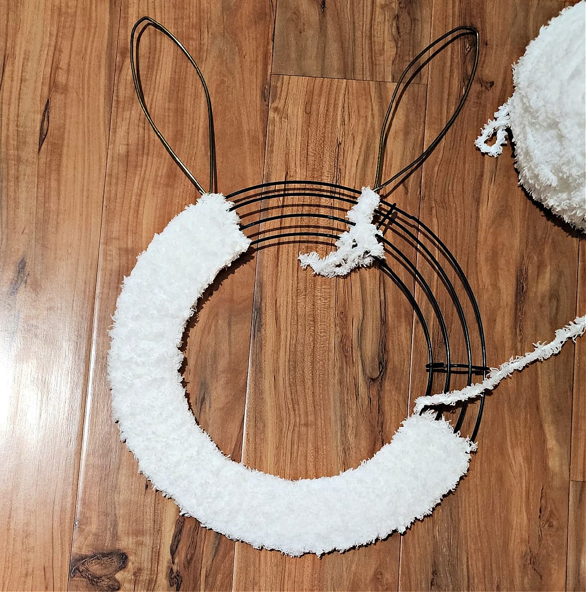 Circular portion of bunny wreath being wrapped with fuzzy yarn.