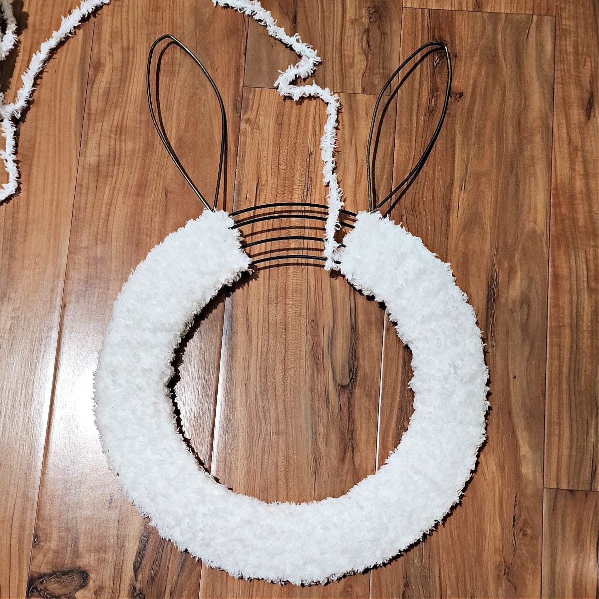Bunny wreath being wrapped with bulky and fuzzy yarn.