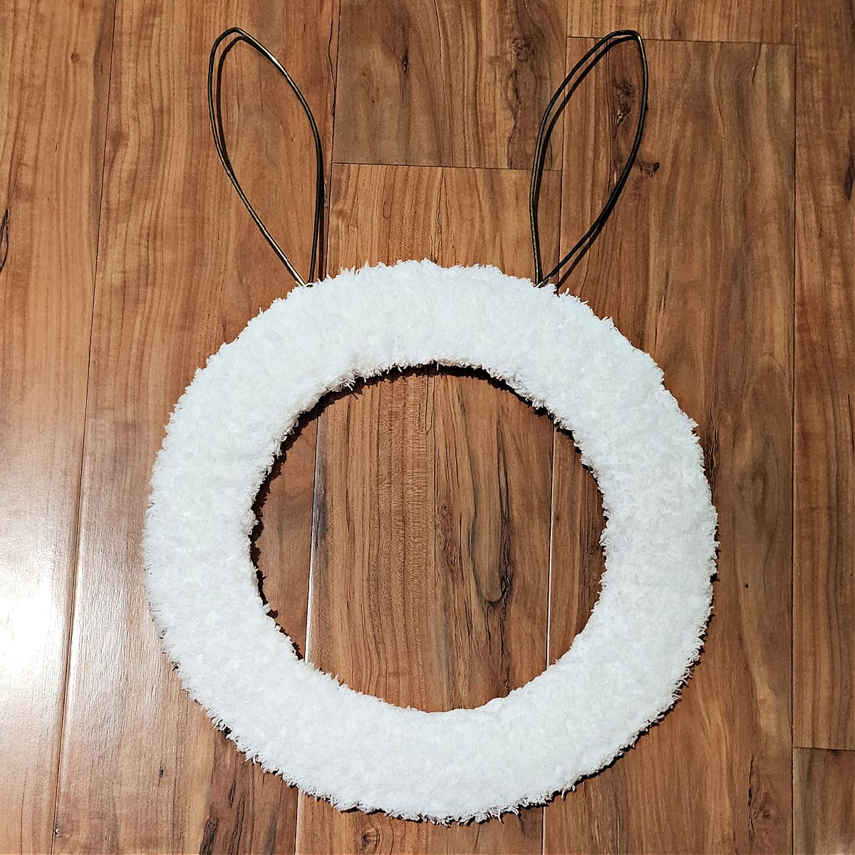 Bunny head wreath wrapped with white pipsqueak yarn.