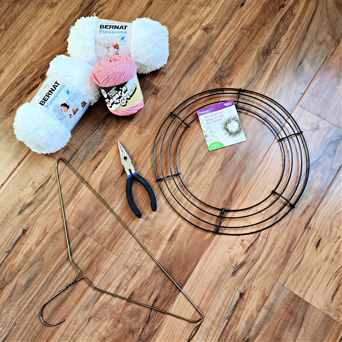 DIY Easter bunny wreath supplies including metal hanger and yarn.