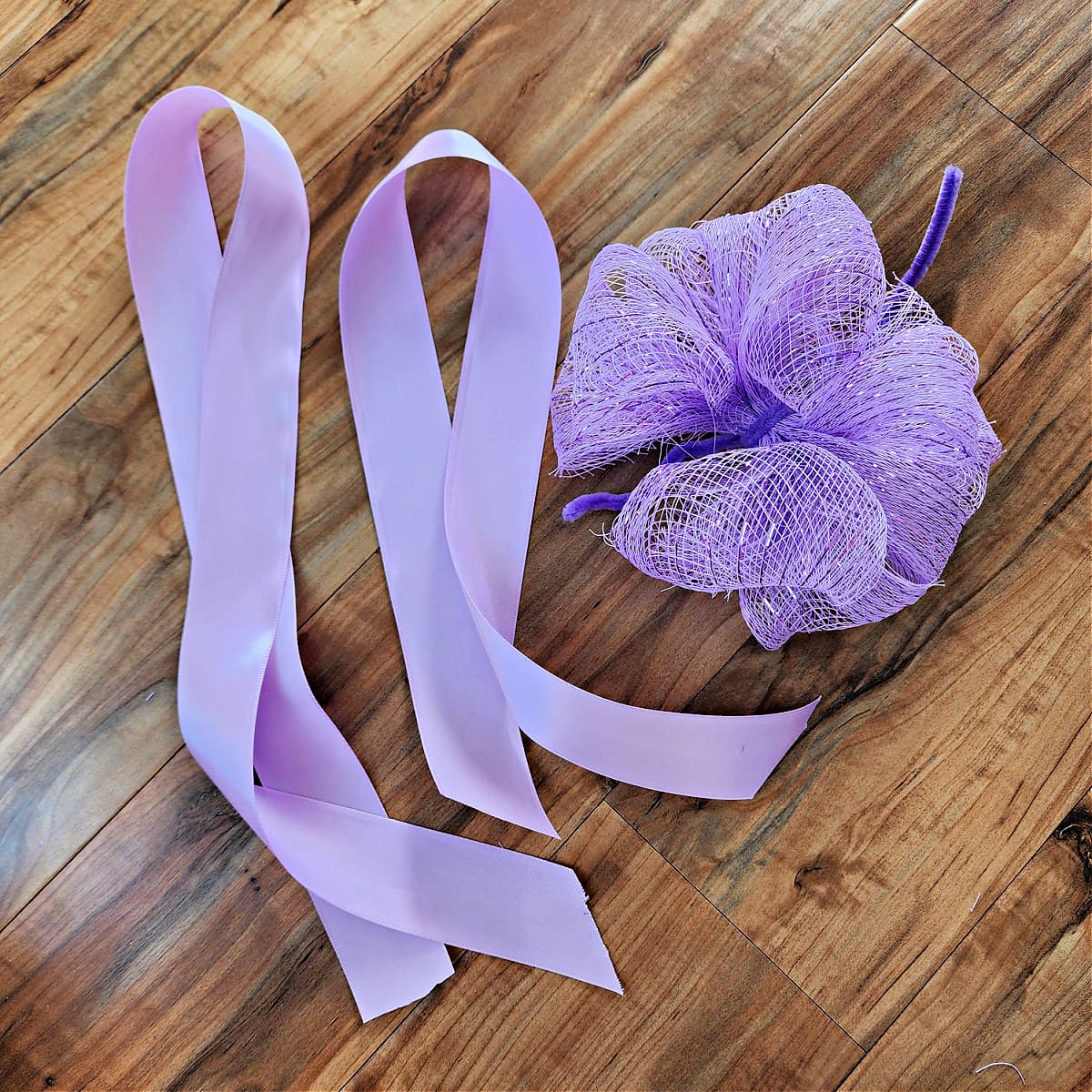 Purple Dollar Tree deco mesh bow with two pieces of 2" wide satin ribbon.