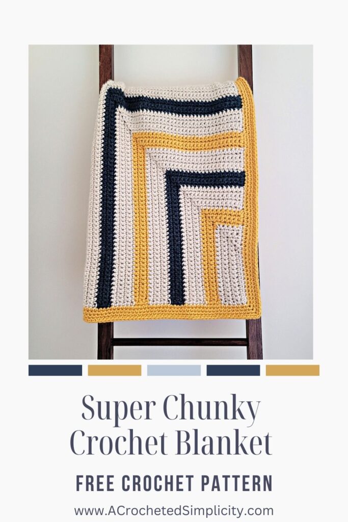 A yellow, cream, and navy blue mitered rectangle crochet blanket made with super bulky 6 yarn.