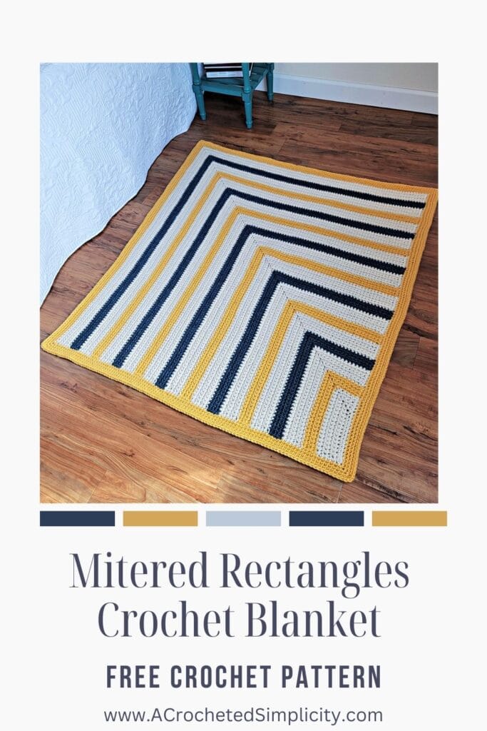 A mitered rectangle crochet blanket made with super bulky 6 yarn in yellow, cream, and navy blue.