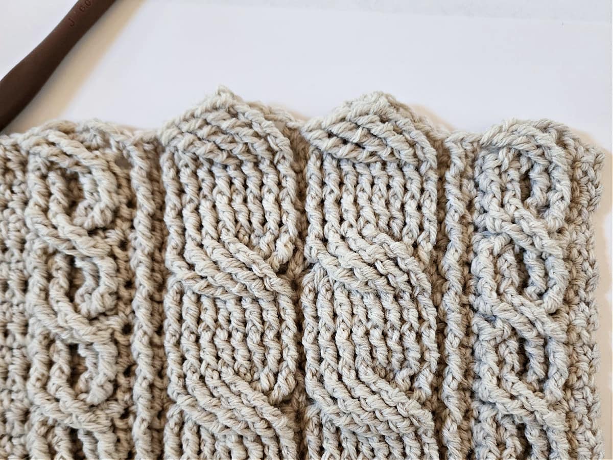 Crochet cable stitch pattern on front of cabled cardigan.