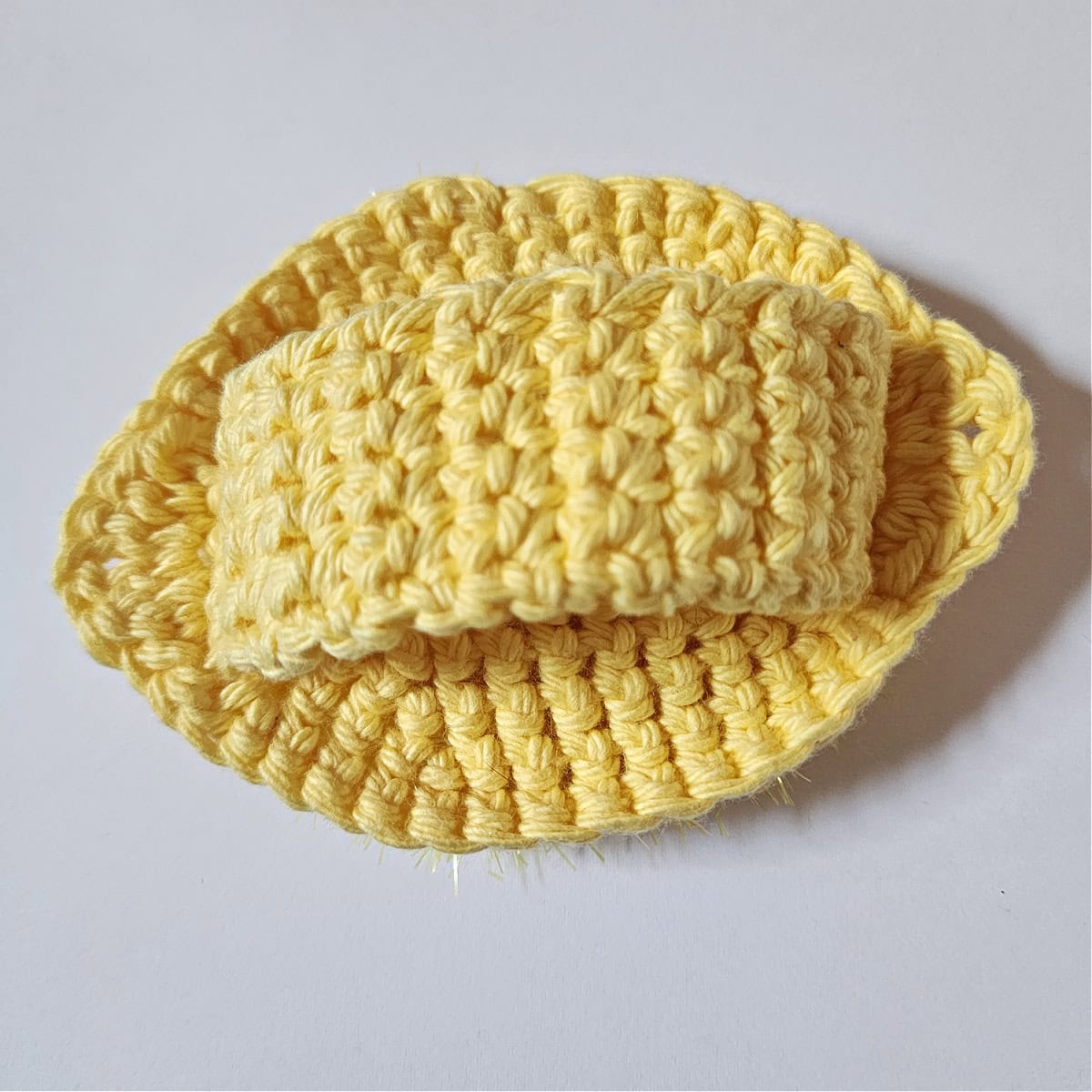 Backside of a completed lemon dish scrubby showing the finger loop.